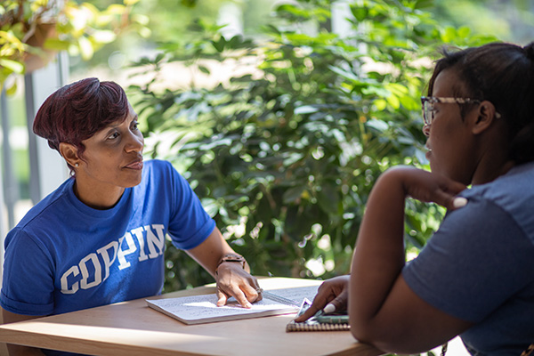 Two students review notes in the lounge